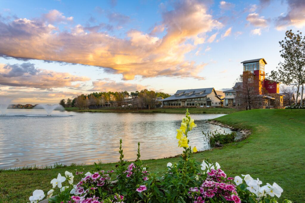 Green park near a lake in Fulshear, with people kayaking and relaxing in a nearby park.