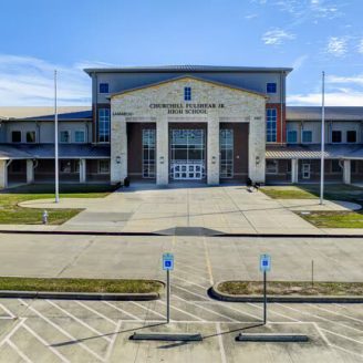 Fulshear, school Students walking toward a modern Lamar CISD school building in Fulshear, Texas, with parents and teachers talking outside.