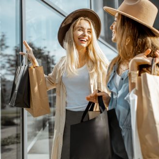 Pattison Texas Shopping Two happy girlfriends looking on the shopwindow while standing with shopping bags near the mall