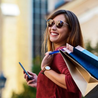 Happy woman in shopping. Consumerism, fashion, lifestyle concept Modern young woman enjoying in shopping. Consumerism, fashion, lifestyle concept