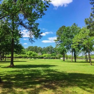 Families walking and biking along scenic trails at Oyster Creek Park near Brohn Homes new construction in Rosharon, Texas.
