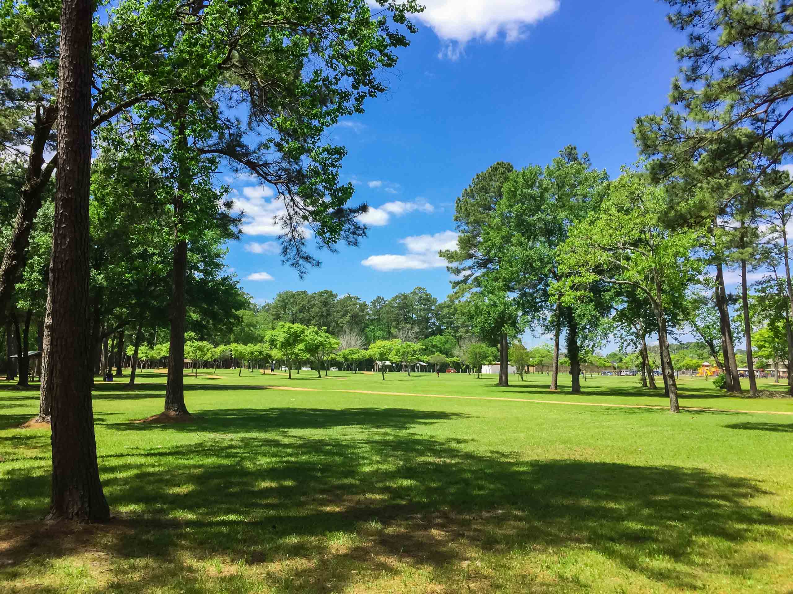 Families walking and biking along scenic trails at Oyster Creek Park near Brohn Homes new construction in Rosharon, Texas.