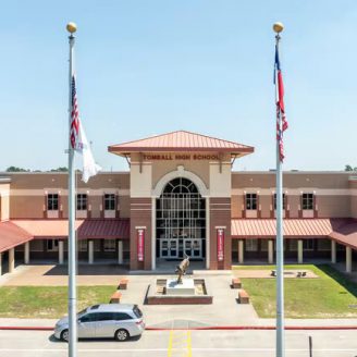 school, Tomball-2 Students entering a modern Tomball ISD school building near Brohn Homes new construction in Tomball, Texas.