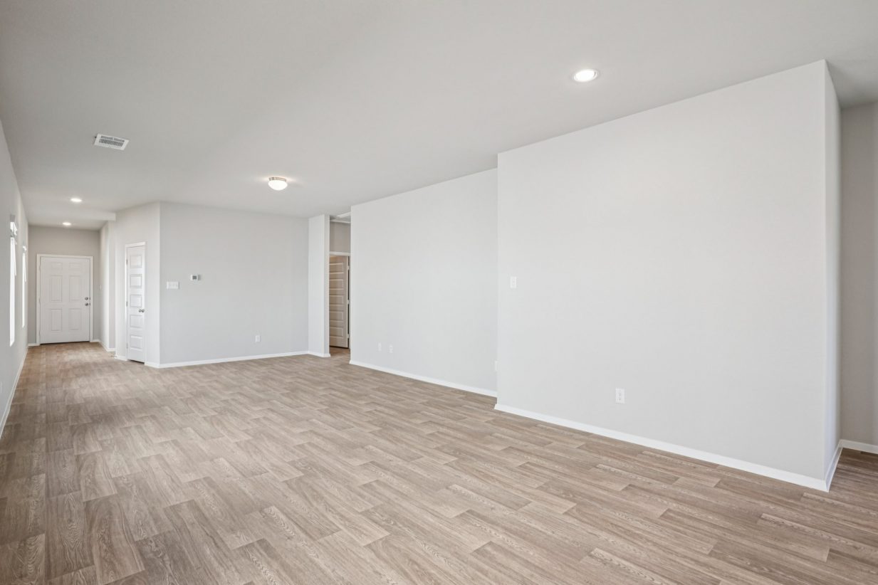 Image of a living room area with vinyl flooring, grey walls, and white trim