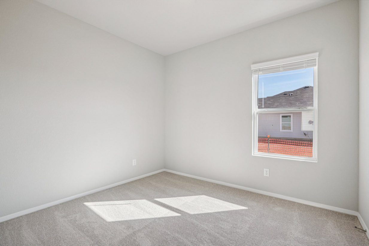 Image of a bedroom with grey walls, carpeting and a window