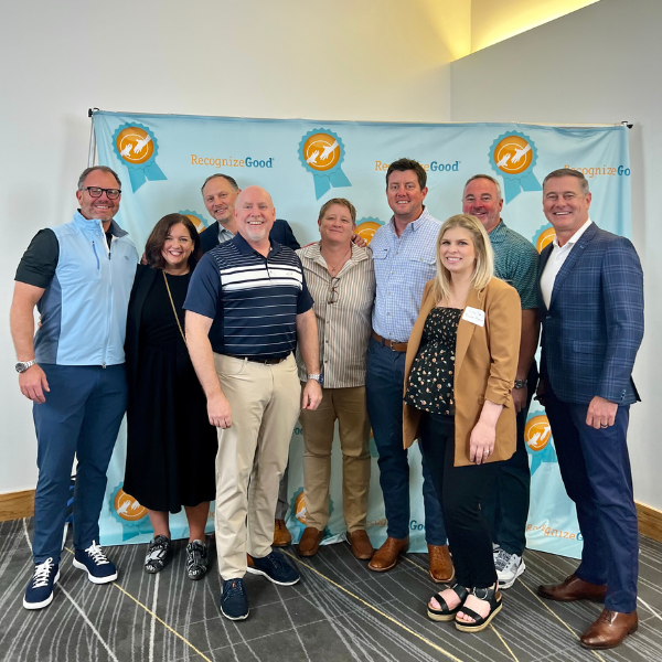 An image of group of people in front of blue and yellow pop up background.