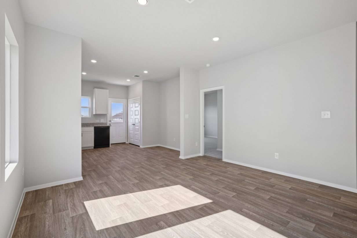 Image of a dining room area with light grey walls, brown vinyl flooring and white trim