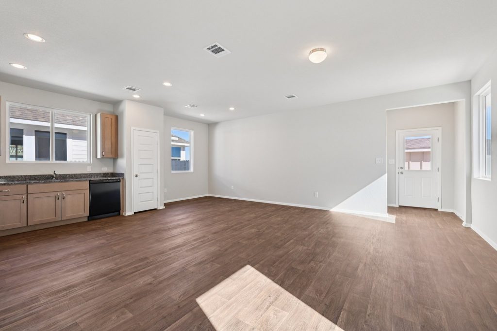 Image of a dining room area with light grey walls, brown vinyl flooring and windows with white trim