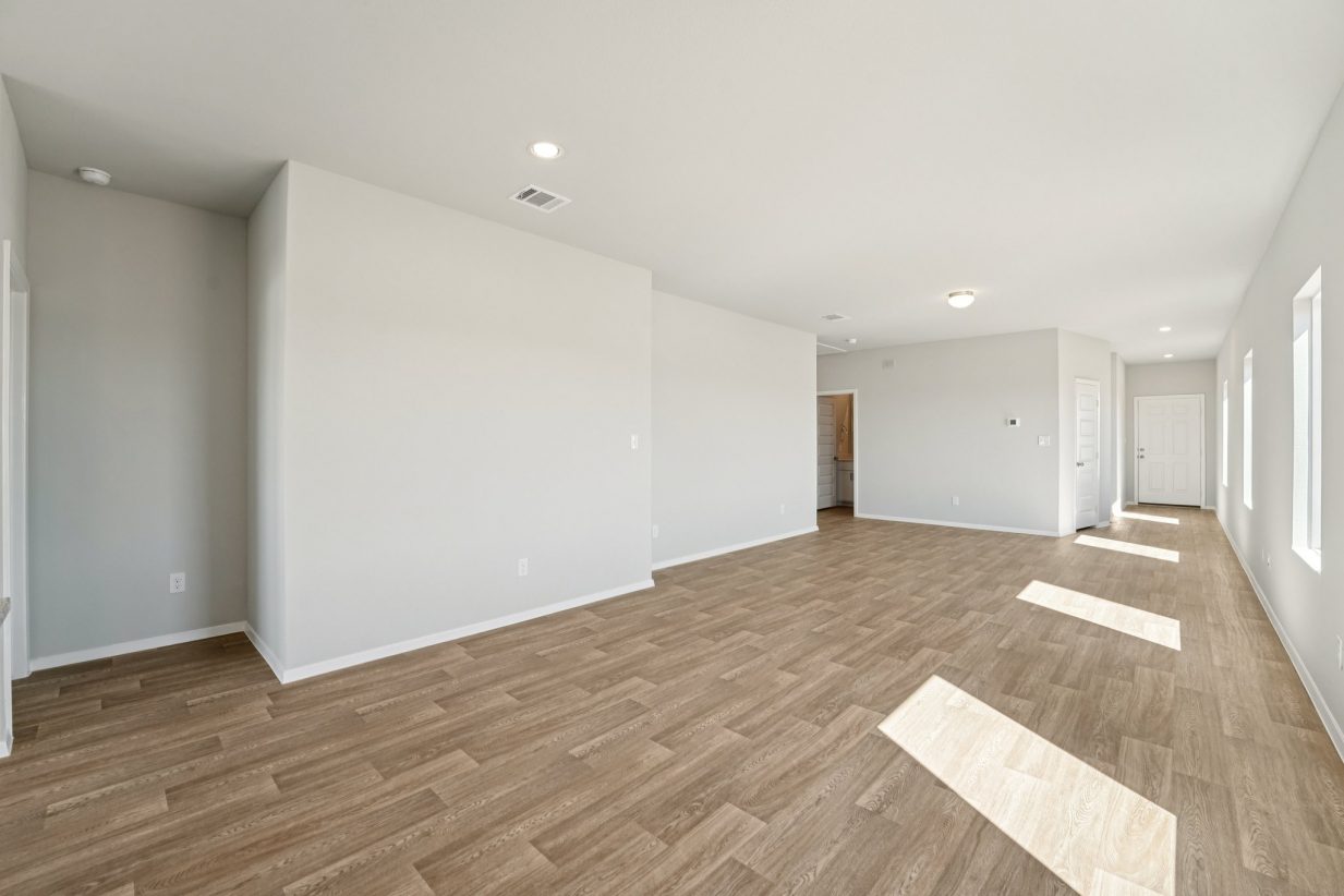 Image of a living and dining room area with grey walls, vinyl flooring and white trim