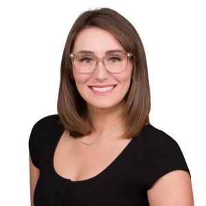 Headshot of woman smiling wearing glasses and a black top