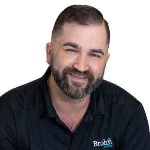 Headshot of smiling man in black polo shirt