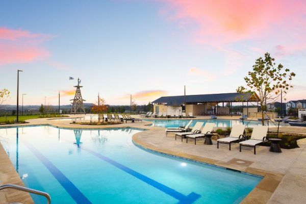 A large pool with lounge chairs and a sunset in the background at Harvest Ridge in Elgin