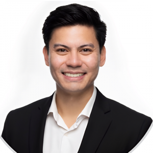 Headshot of man with dark hair smiling wearing a white button up shirt and black jacket