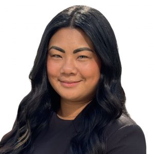 Headshot of smiling woman with long, dark hair wearing a black top with a white background