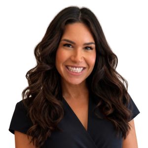 Headshot of woman with long, dark, curled hair, smiling, wearing a black top