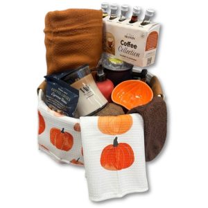 Photo of gift basket with blanket, coffee syrup, candle, pumpkin kitchen towels, and more